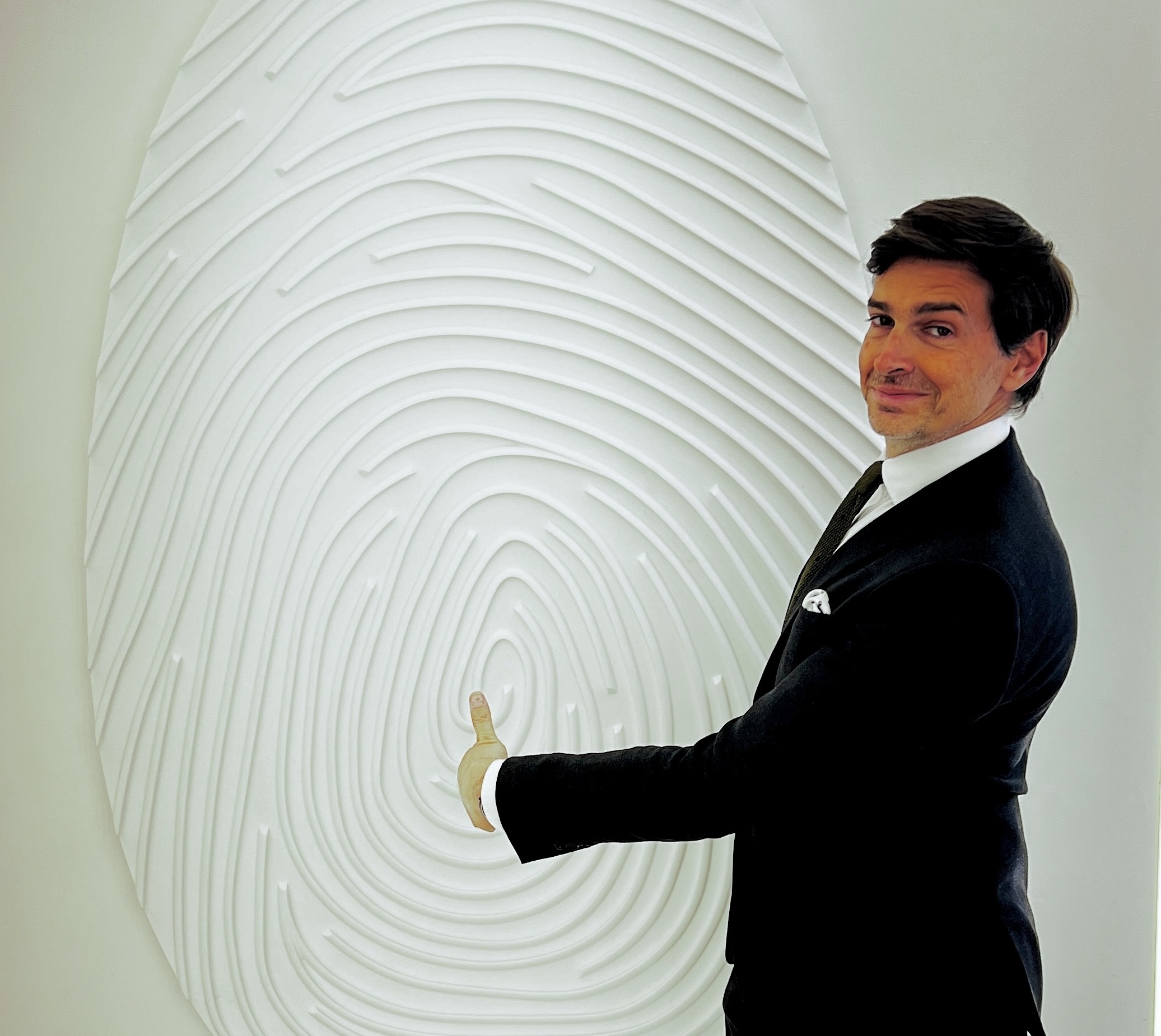 Guillaume Duprat, formateur en vente de luxe, devant l'empreinte digitale emblématique de Christian Dior, symbole d'élégance et de personnalisation
